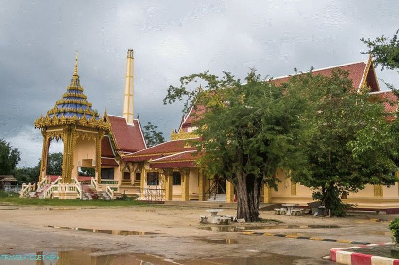 Zelo tajska fotografija: krematorij, tempelj, miza pod drevesom, luže in hitrostna udarec na glineni cesti.