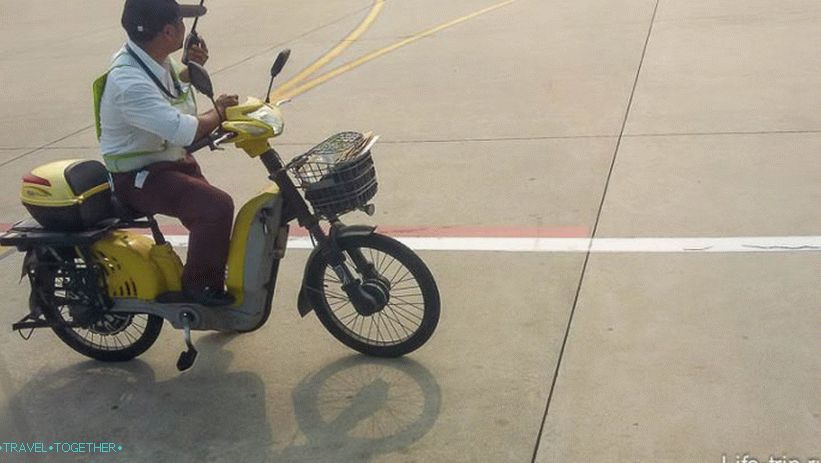 V Sanyi, na letališču, delavci gredo na kolesa